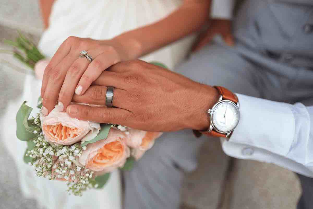 matrimonio: la mano dello sposo e della sposa durante la cerimonia nuziale